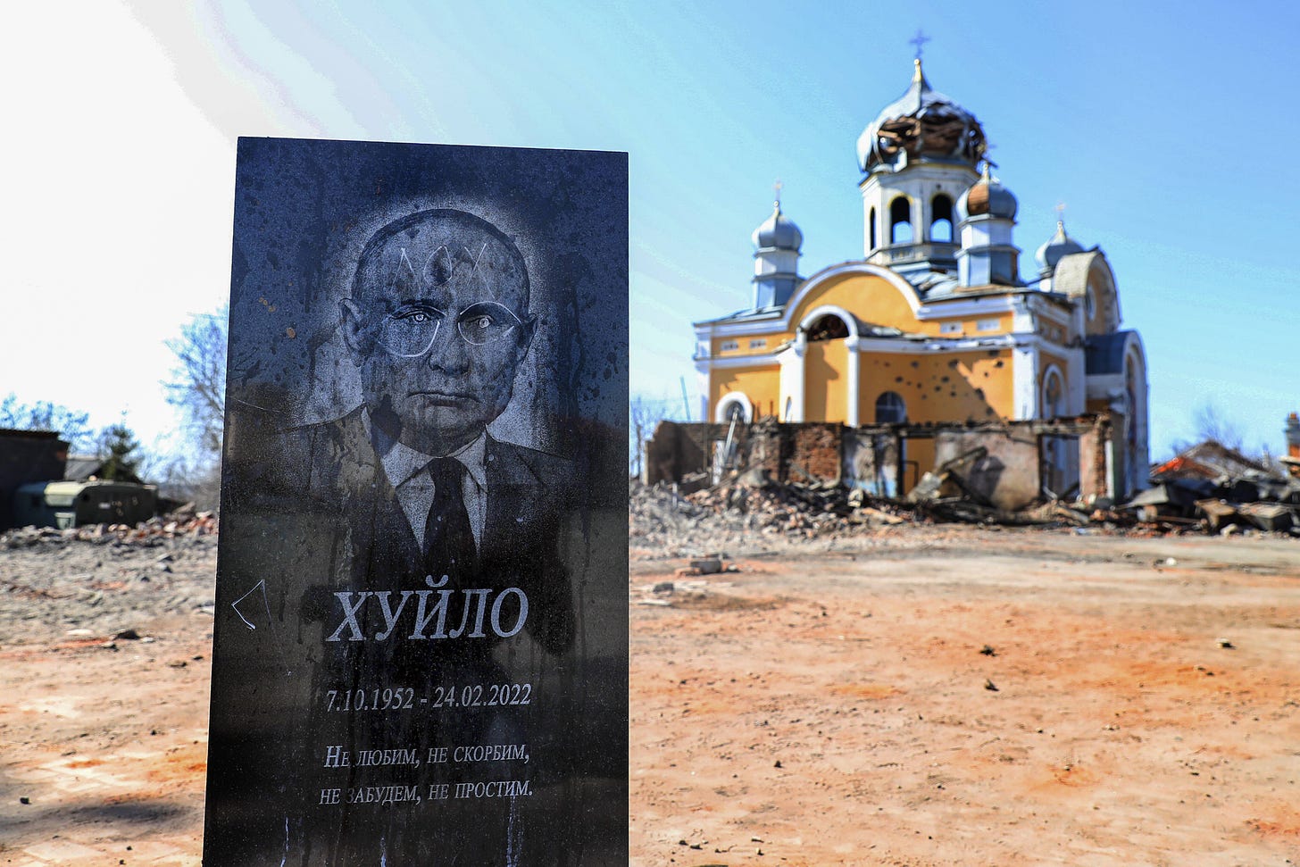 A sign excoriating Russian President Vladimir Putin for his invasion of Ukraine is seen outside a partially destroyed church in Malyn, Ukraine, on March 22. (Nuno Veiga/EPA-EFE/REX/Shutterstock)