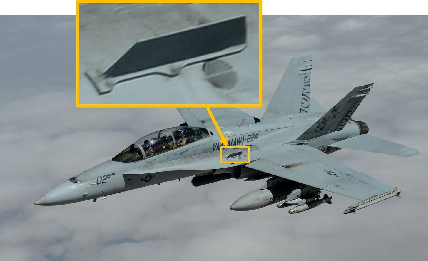 A twin-seat F/A-18 Hornet with a zoomed section highlighting one of the fences on the top of the aircraft