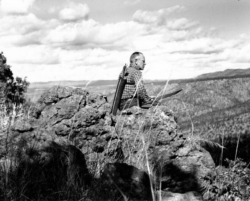 Aldo Leopold sitting on a rock