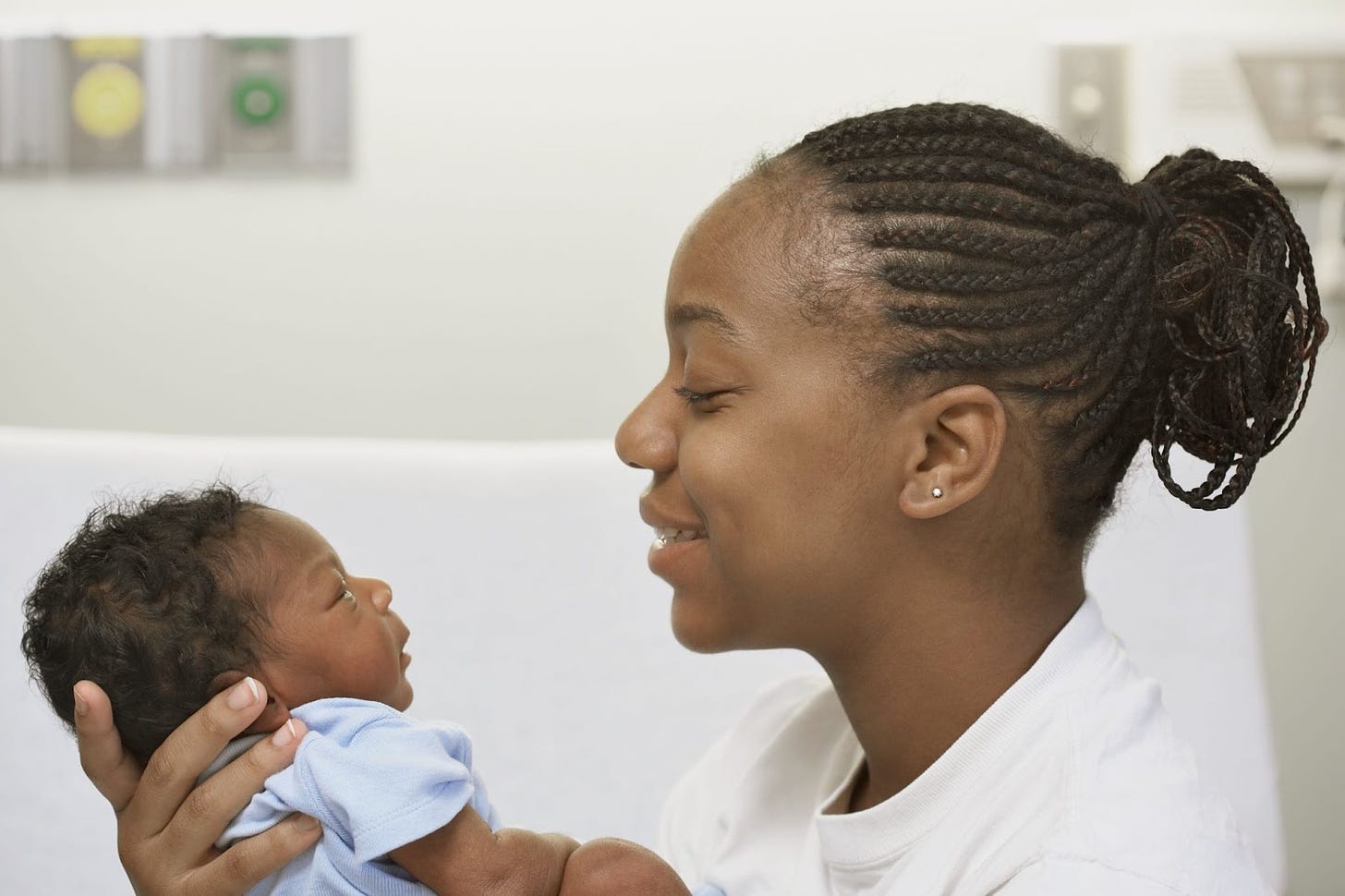 Black mother looking at and smiling at her baby