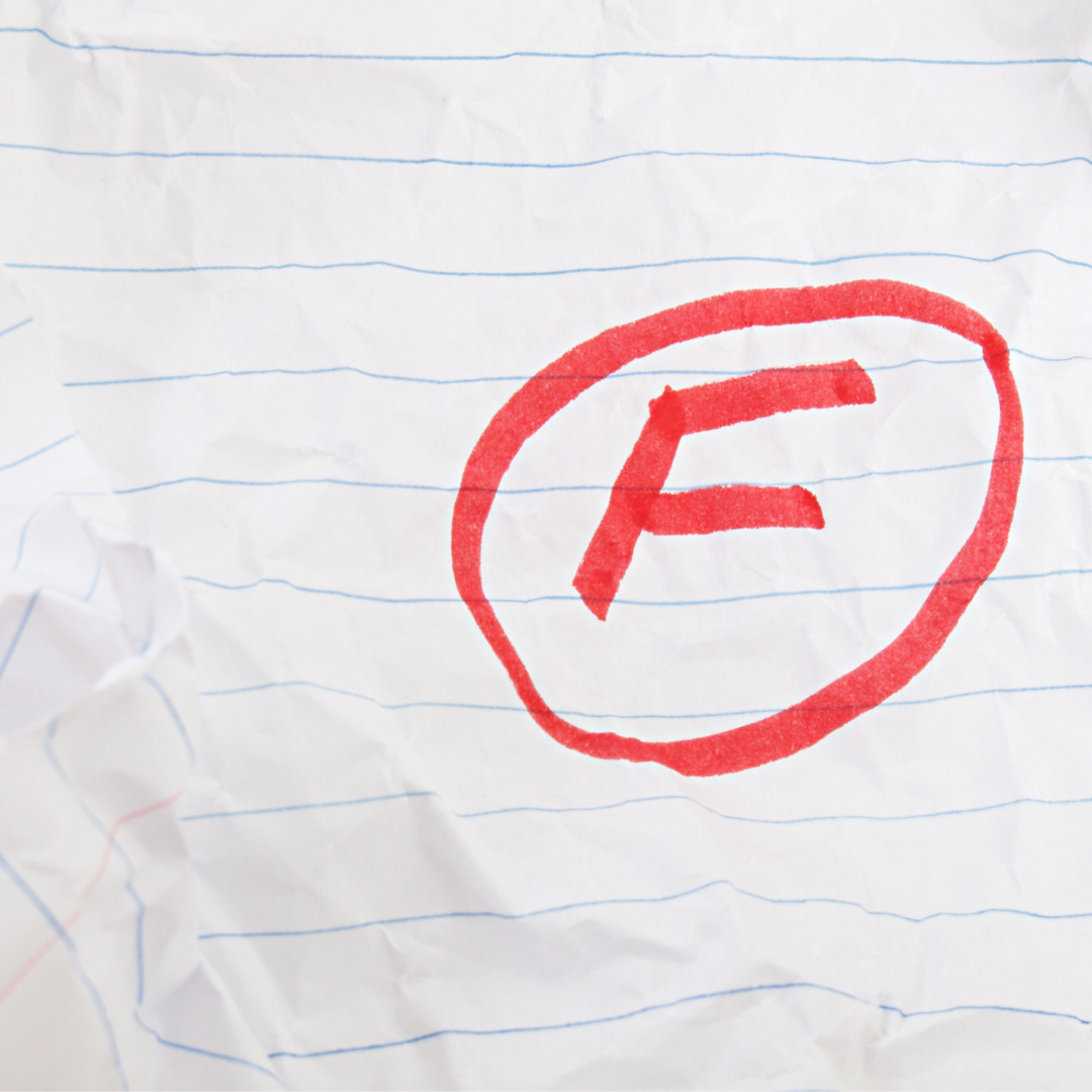 Letter F inside a circle in red pen on a piece of crumpled ruled paper.