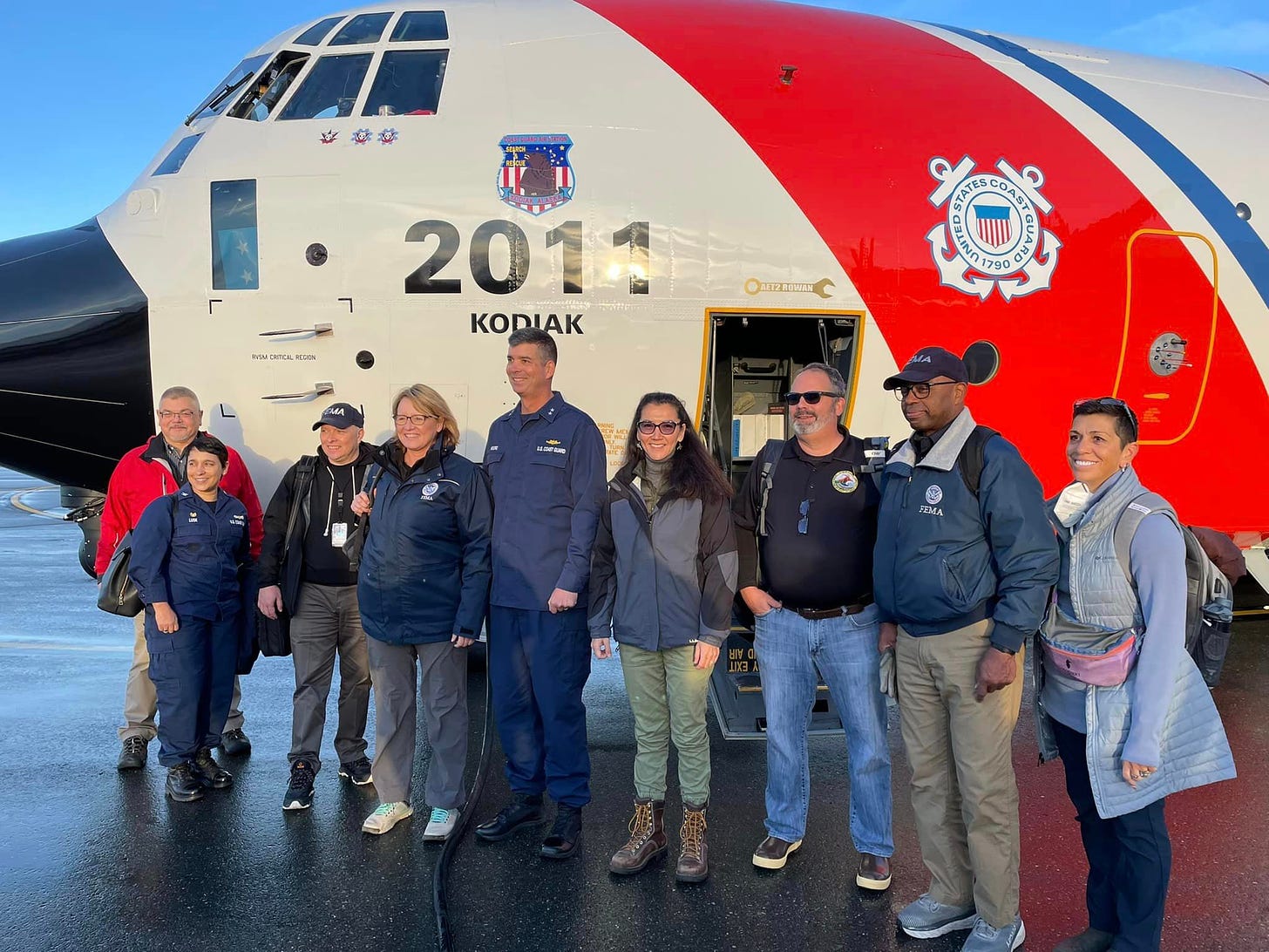 Rep. Peltola and a group of people stand in front of a Coast Guard airplane.