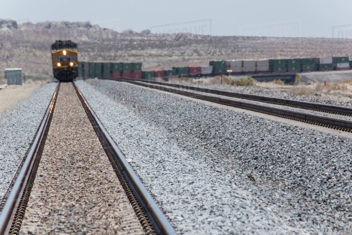 Train approaching on railroad track - Stock Photo - Dissolve