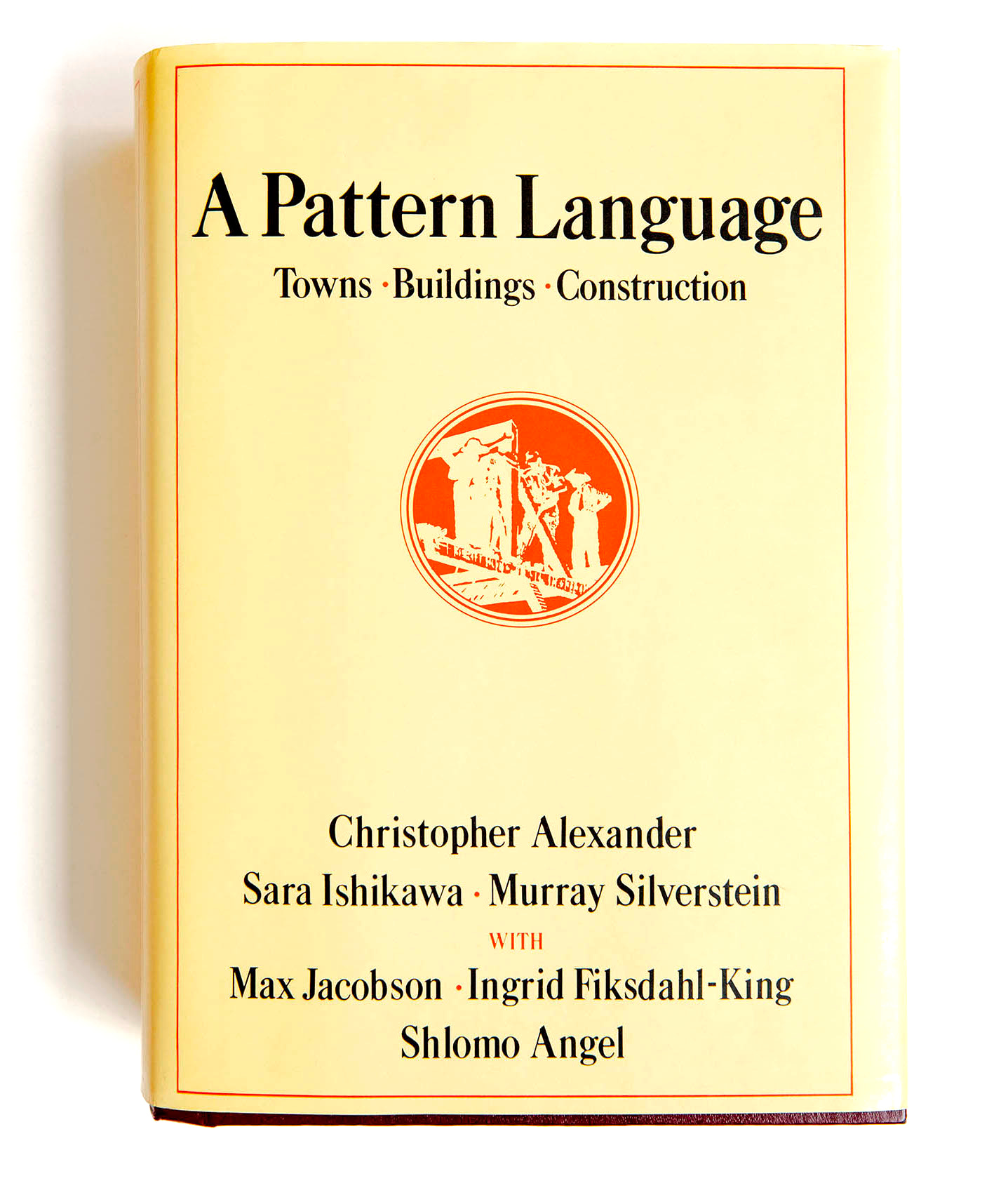 A photo of the hardcover book, “A Pattern Language.” It has a yellow cover with a little orange seal in the middle, but I can’t quite tell what it’s depicting.