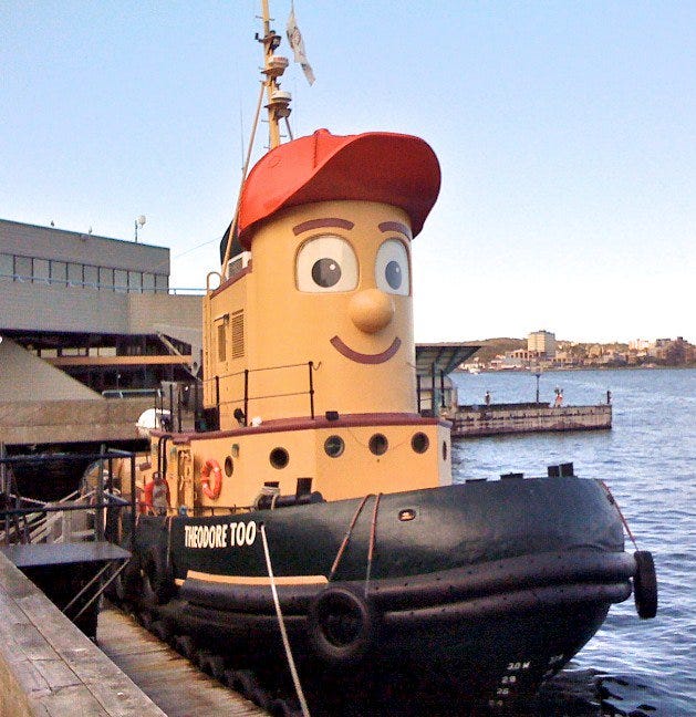Cute Tugboat called Theodore 100 who has a face, cartoon eyes, a cute button nose and a red cap.