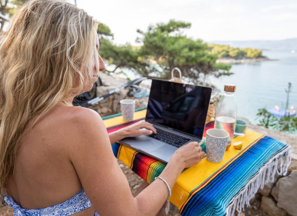 Woman working online with sea view