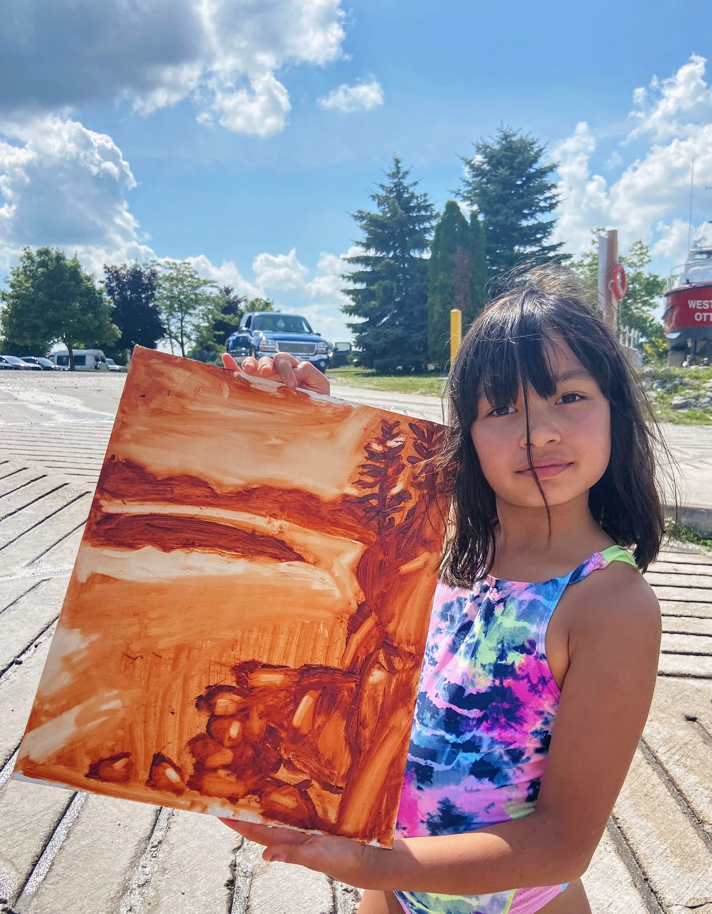 Child holding up painting