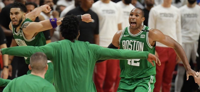 Boston Celtics players celebrate after defeating the Miami Heat in Game 7 at FTX Arena.