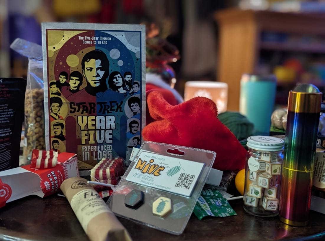 A table filled with presents! Centered is a Star Trek graphic novel. It's a picture that feels warm and cozy.