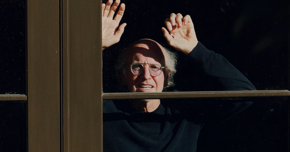 Larry David staring through window