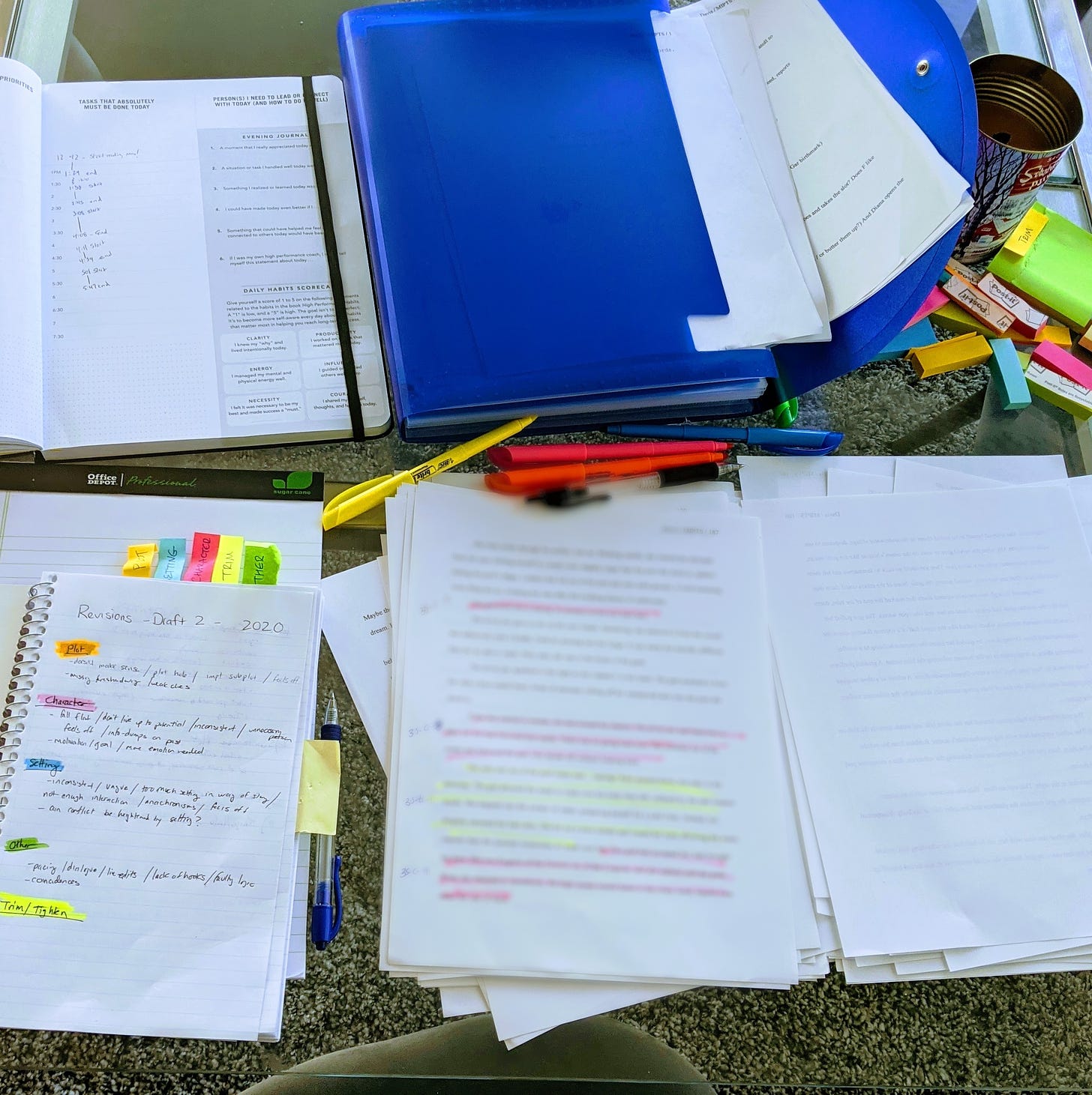 journals and notes and sticky notes scattered across a glass table