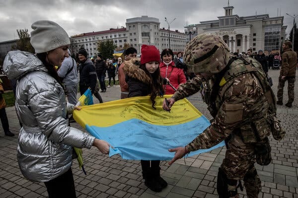 A Ukrainian soldier signing a flag in the main square of Kherson on Sunday.