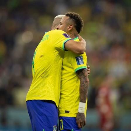 o jogador da seleção Richarlison abraça Neymar enquanto o mesmo está imóvel