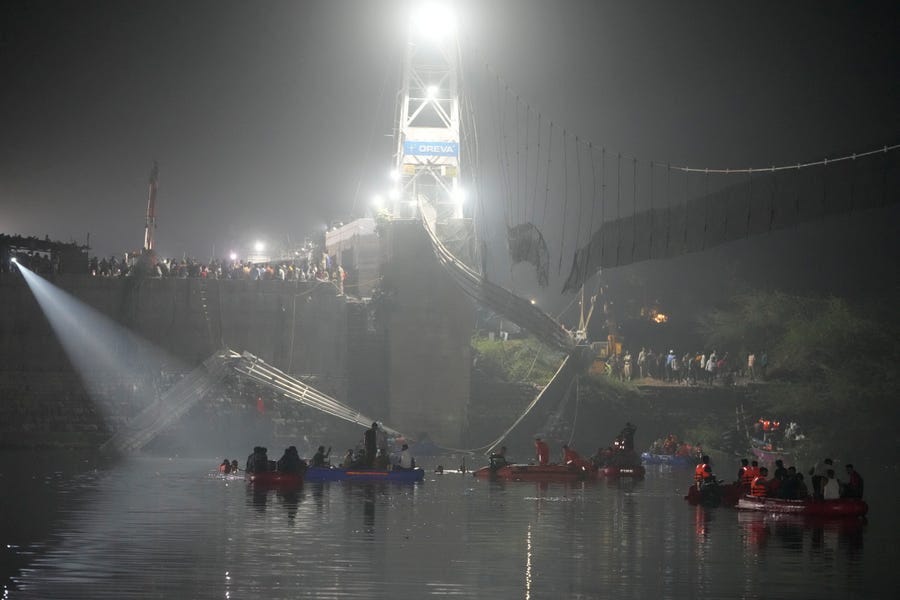 Rescuers on boats search in the Machchu river next to a cable suspension bridge that collapsed in Morbi, India, Monday, Oct. 31, 2022.