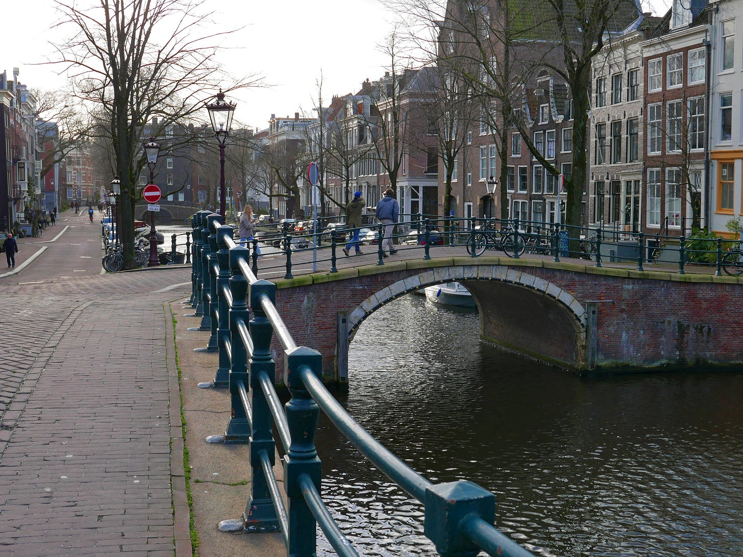 "Canal view in Amsterdam downtown with old brick bridge over the water of Reguliersgracht; free photo by Fons Heijnsbroek, january 2022" by Fons Heijnsbroek is licensed under CC BY-SA 4.0.