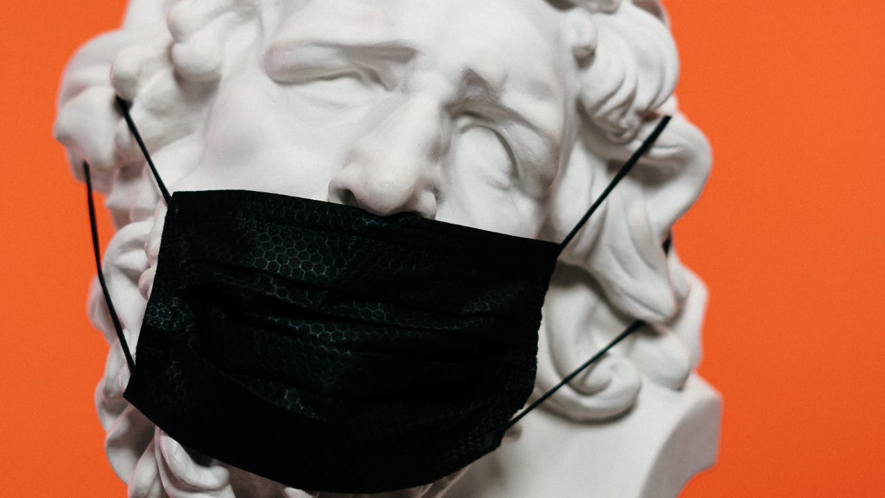 A sculpture wearing a mask