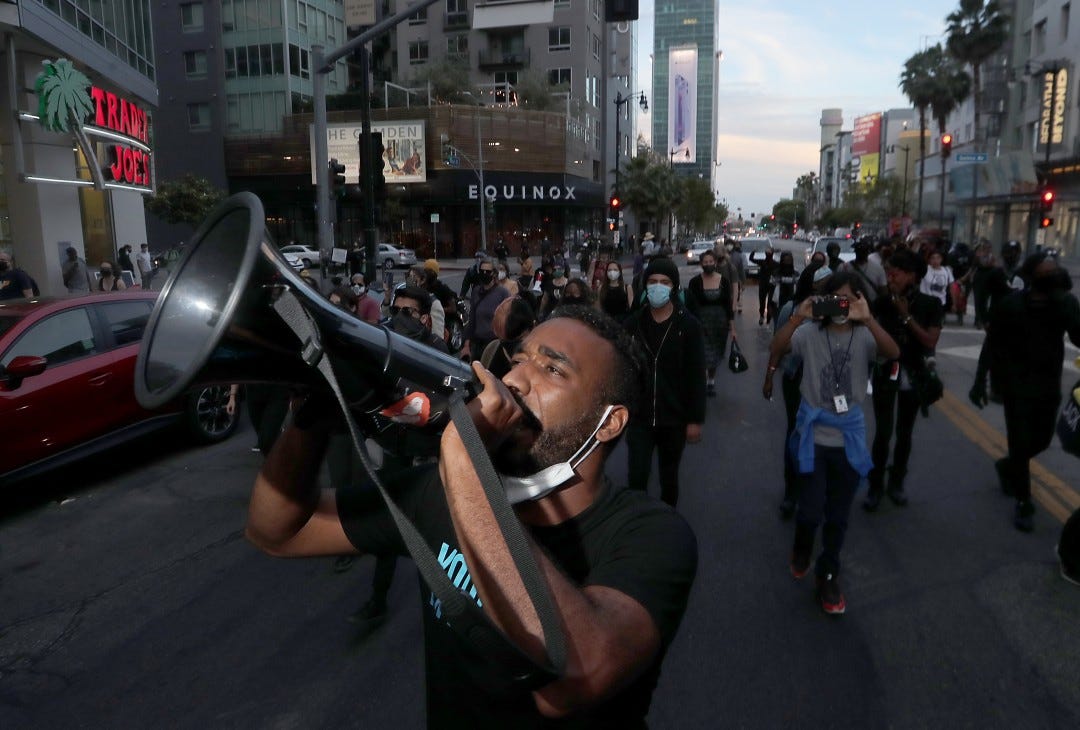 A man with a loudspeaker participates in a march down Vine Street in Hollywood.