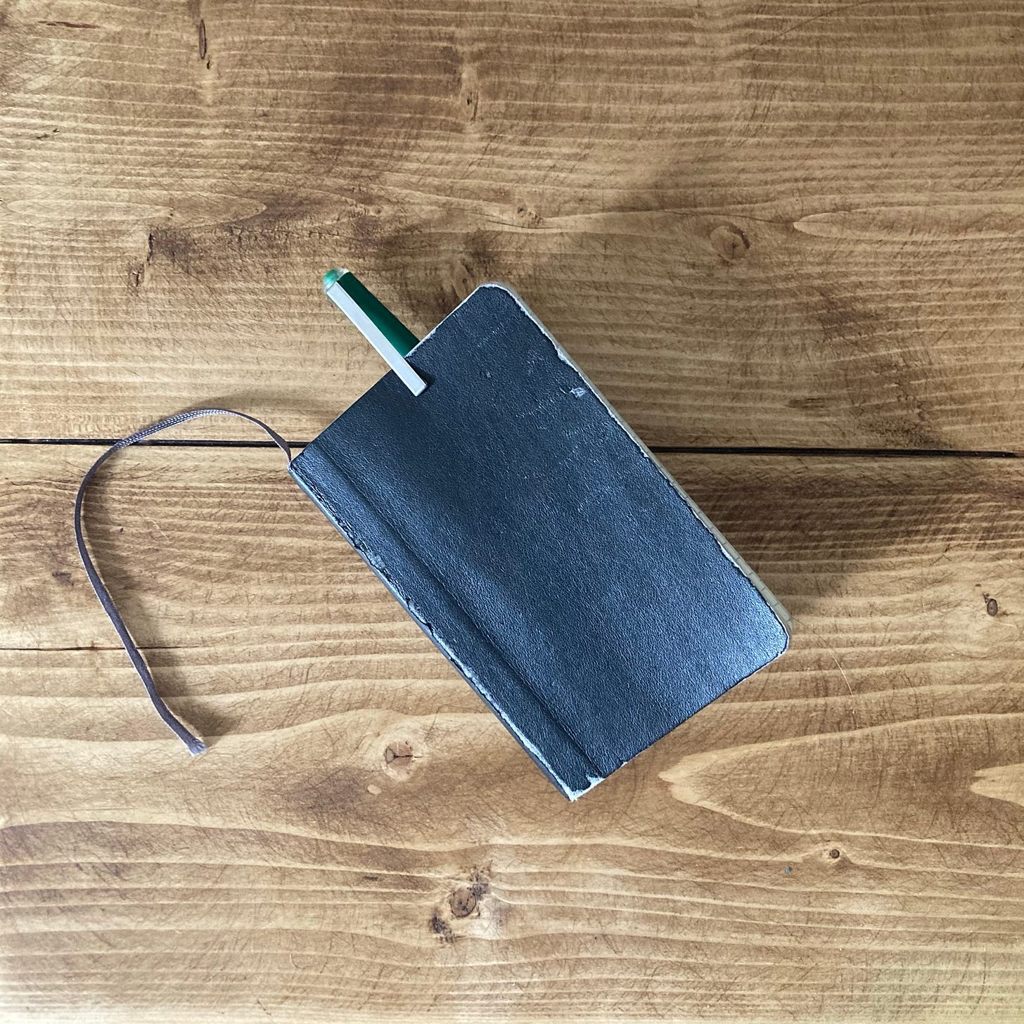 A battered, pocked-sized notebook