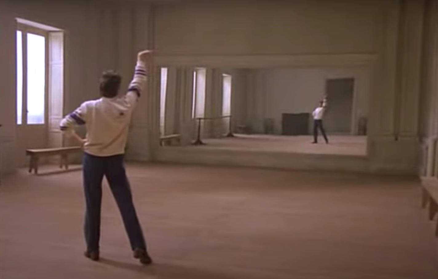 In a freeze-frame from the Carlos Saura film Bodas de Sangre, dancer Antonio Gades is in a striking, macho pose in an empty dance studio as he warms up before a dress rehearsal.