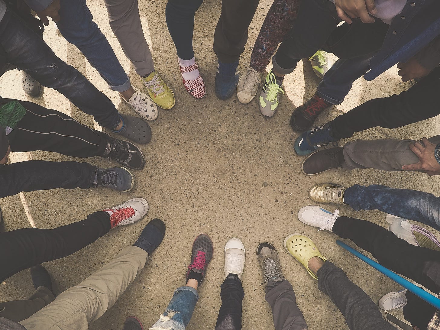 A group of people putting their feet in a circle.