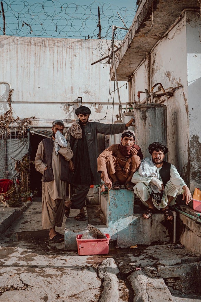 Addicts sit outside of their cell block at Kandahar Prison.