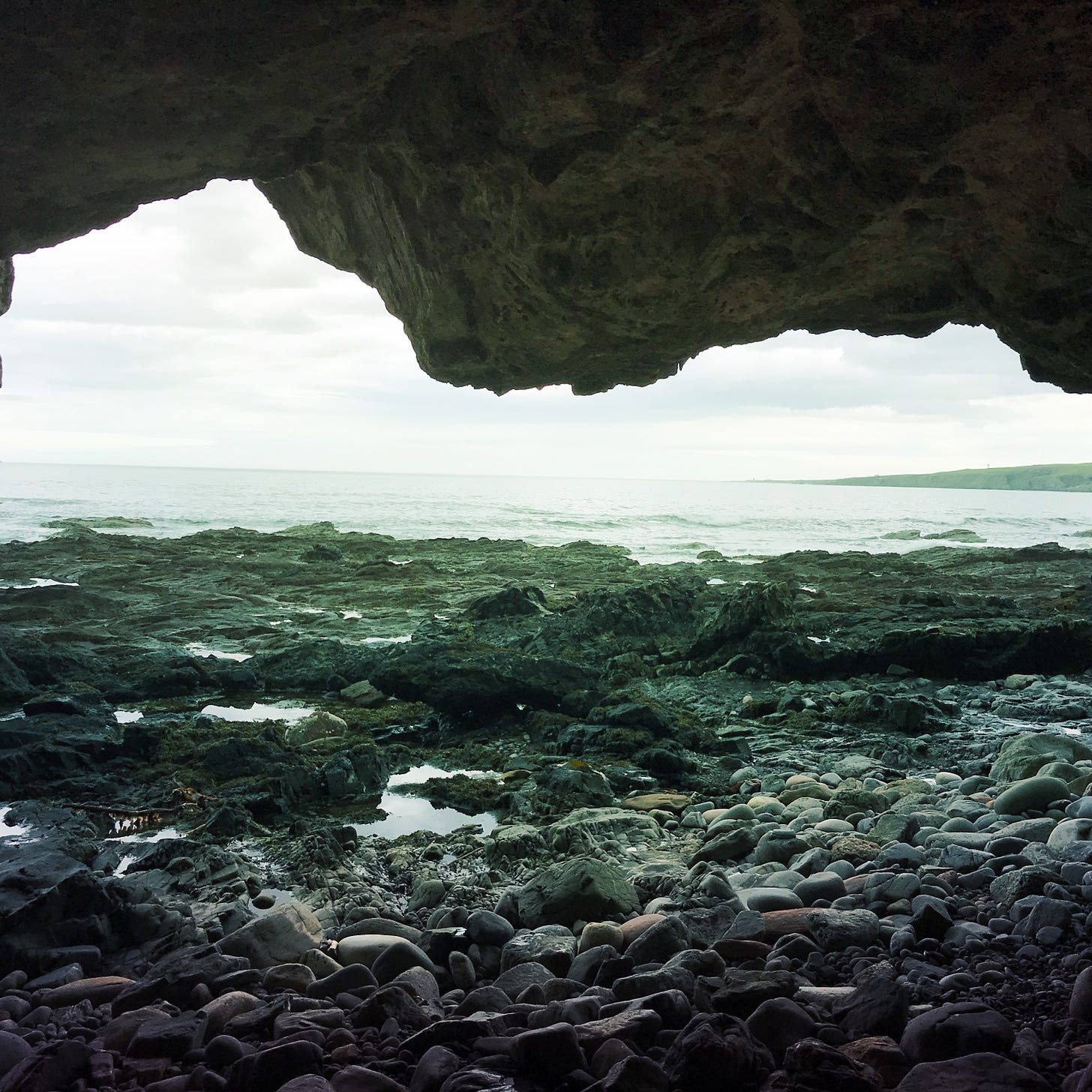 a photo of the inside of a cave, looking out to the North sea. 