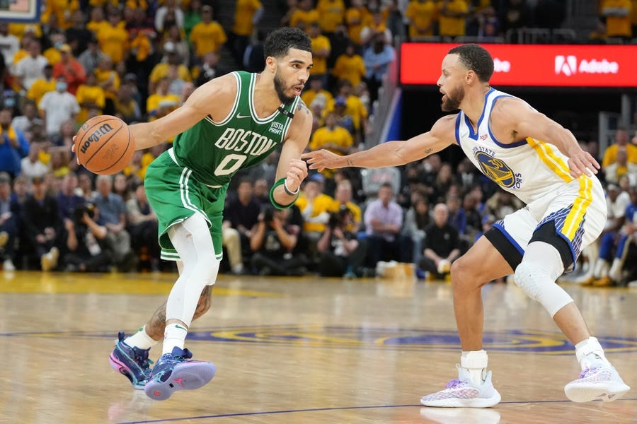 Boston Celtics forward Jayson Tatum (0) dribbles the ball while defended by Golden State Warriors guard Stephen Curry (30) during the second half in game one of the 2022 NBA Finals at Chase Center.