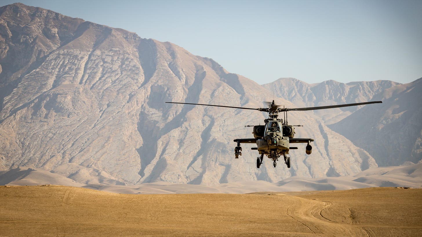A low flying Apache helicopter flies over the Afghanistan desert.
