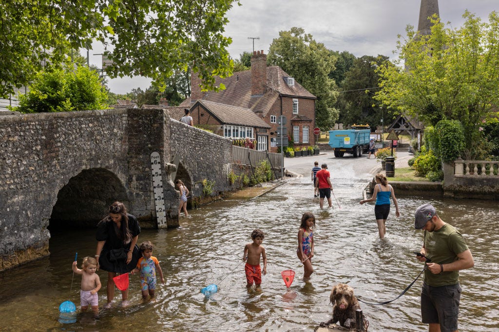 Families cool off in the River Darent on July 12, 2022 in Eynsford, United Kingdom.