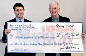 Richard Hatcher, director of the Oklahoma Department of Wildlife Conservation, and Larry Potterfield, founder of MidwayUSA Inc., hold a symbolic check for more than $2.1 million, representing the total money donated over three years by MidwayUSA Foundation and the Potterfield family for the Oklahoma Scholastic Shooting Sports Program. 