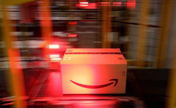 A package with the Amazon logo moves on a conveyor.
