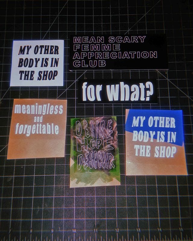 Six different stickers with different text slogans laying on a grid layout cutting mat