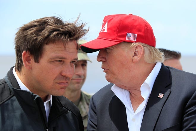 President Donald Trump talks to Florida Gov. Ron DeSantis, left, during a visit to Lake Okeechobee and Herbert Hoover Dike at Canal Point, Fla., on March 29, 2019.