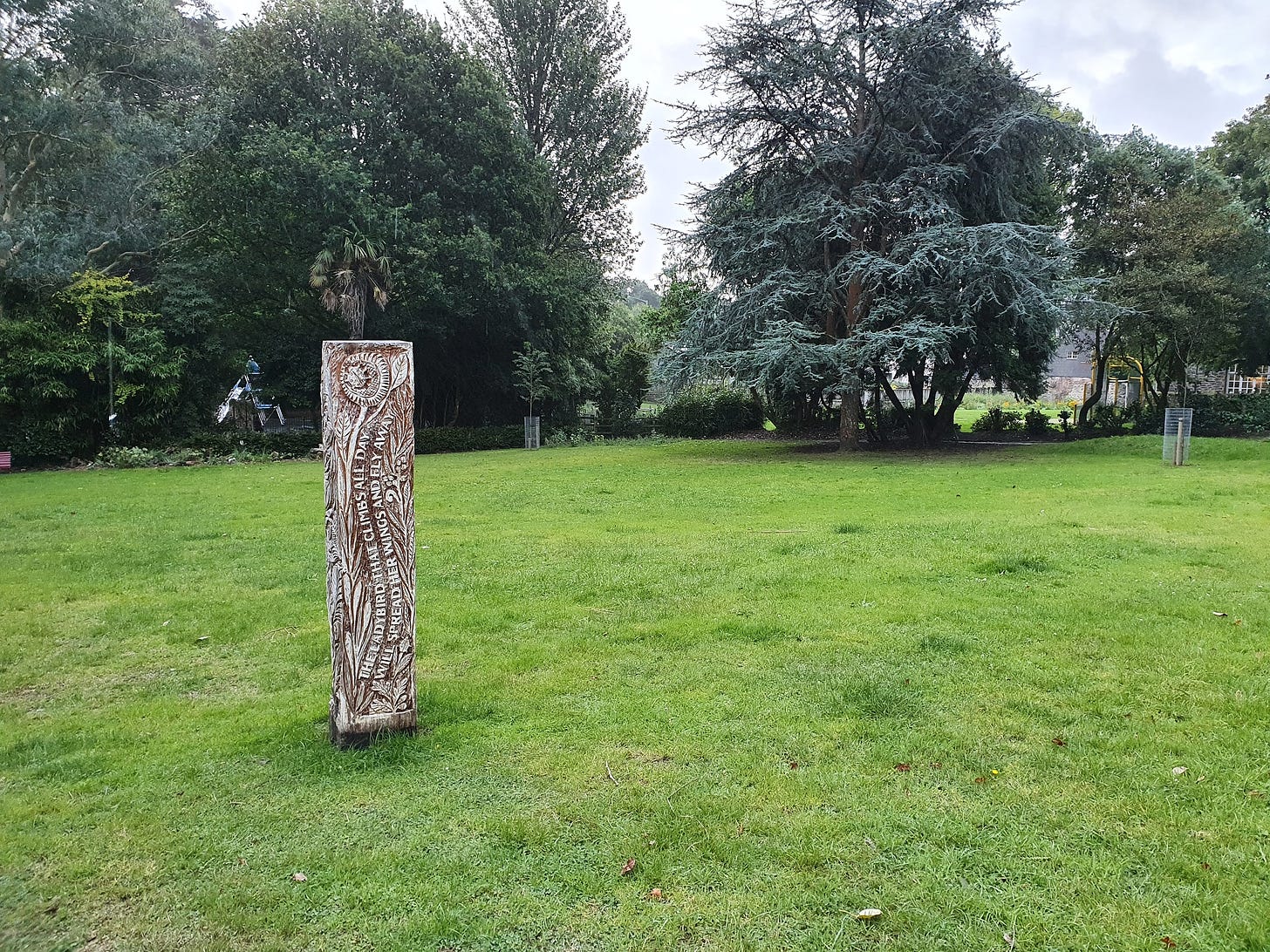 The ‘ladybird sculpture’ in Trelawney Park, Penryn, Cornwall: a four-sided carved wooden pillar with plant, insect and bird motifs
