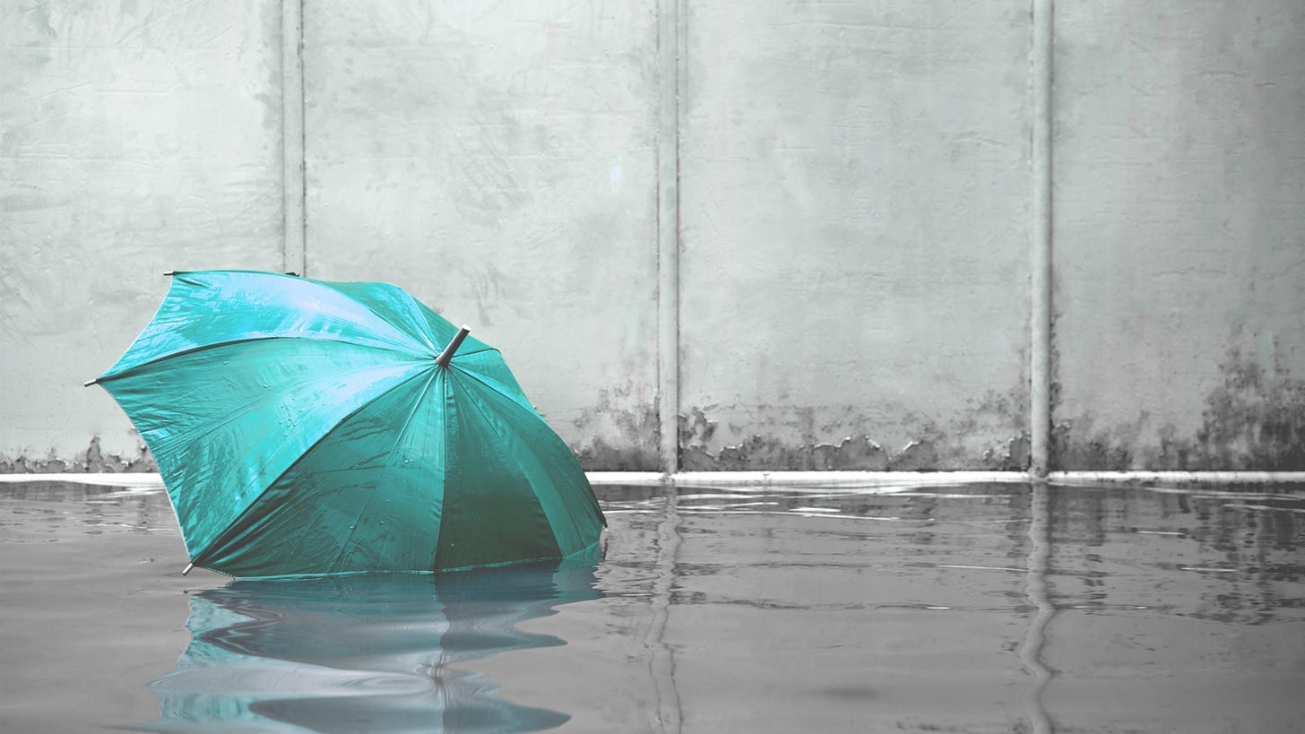 green umbrella on a flooded floor