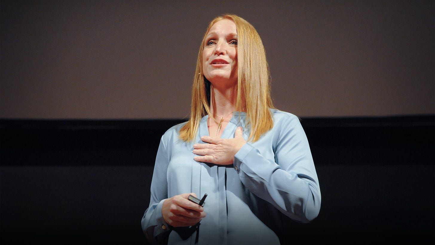 Picture of blond woman wearing a light blue blouse speaking to an audience