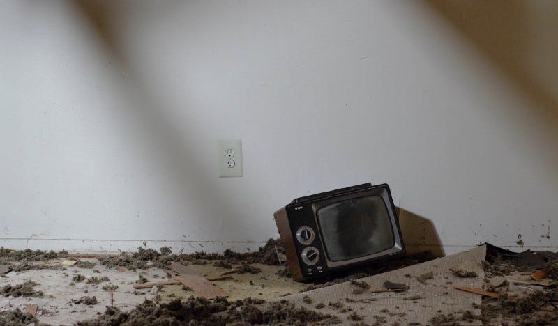 Old television on ground with debris