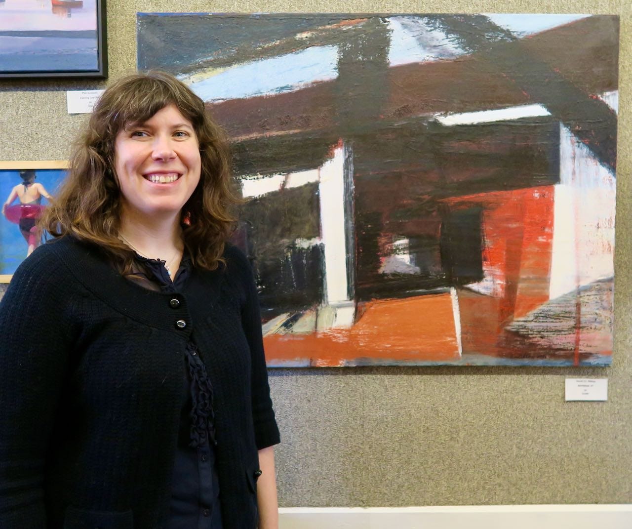 A person smiling in front of a painting

Description automatically generated with low confidence
