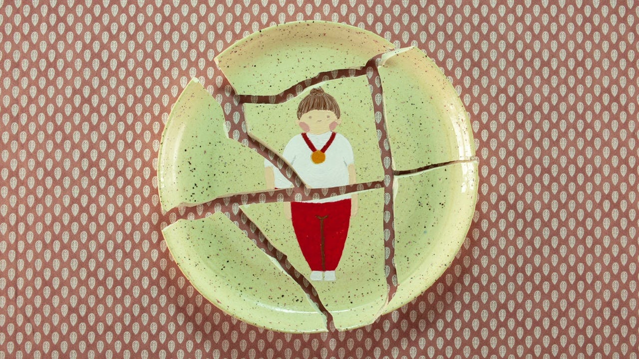 A broken plate with a drawing of a girl on it. 