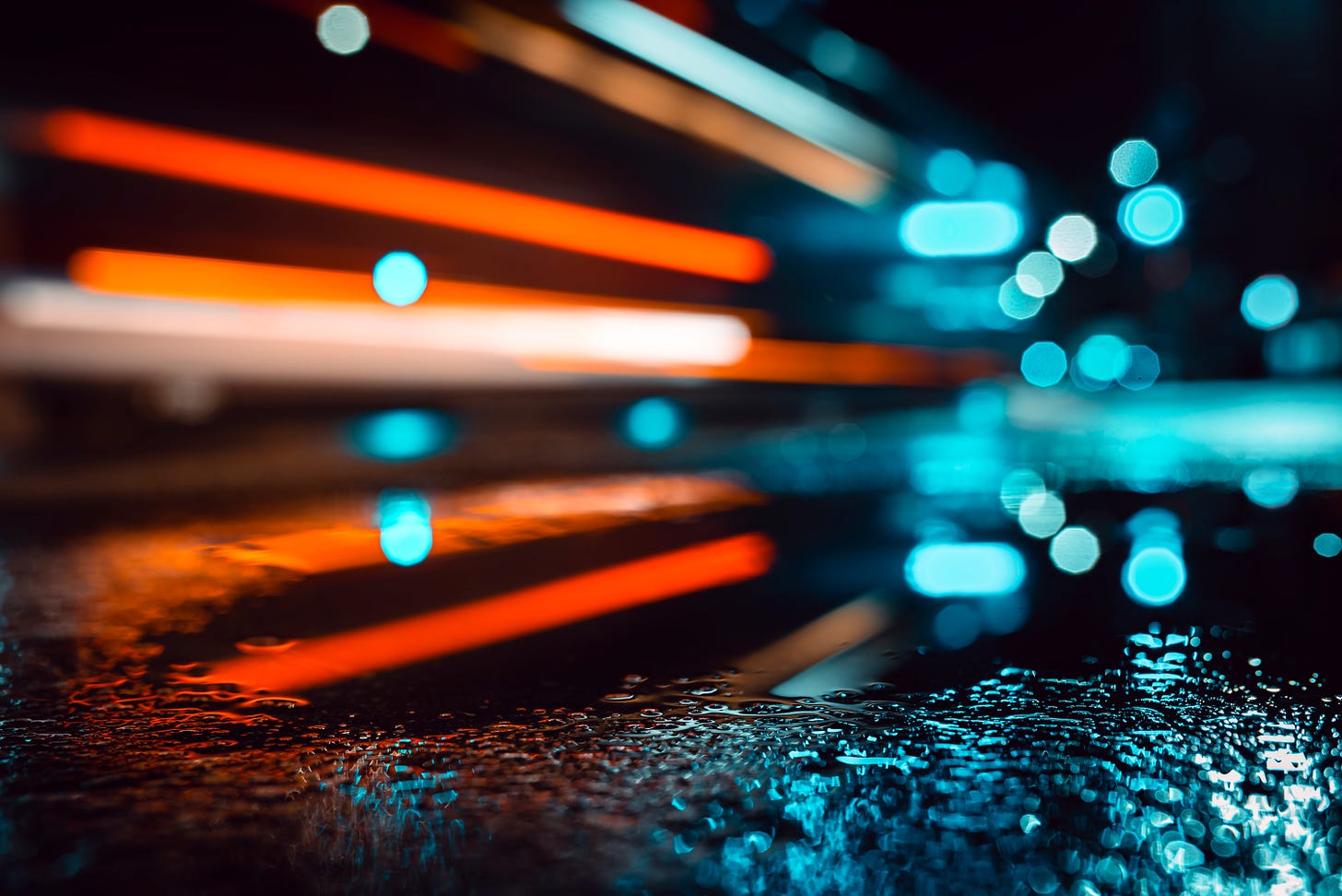 streaks of automobile lights over wet pavement
