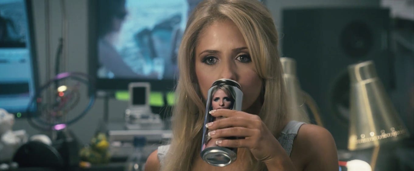 Movie still from Southland Tales. A blonde woman drinks from a pop can with a picture of herself on it.