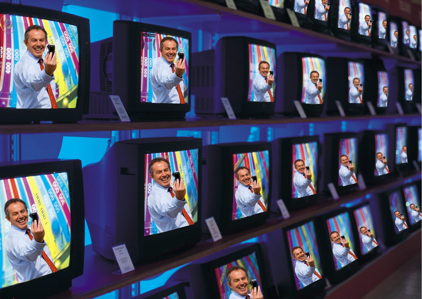 A wall of TVs, all with Tony Blair on them