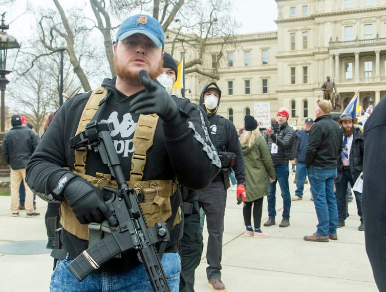 Men dressed in quasi-military outfits and carrying guns at a protest in Lansing, Michigan in April 2020.