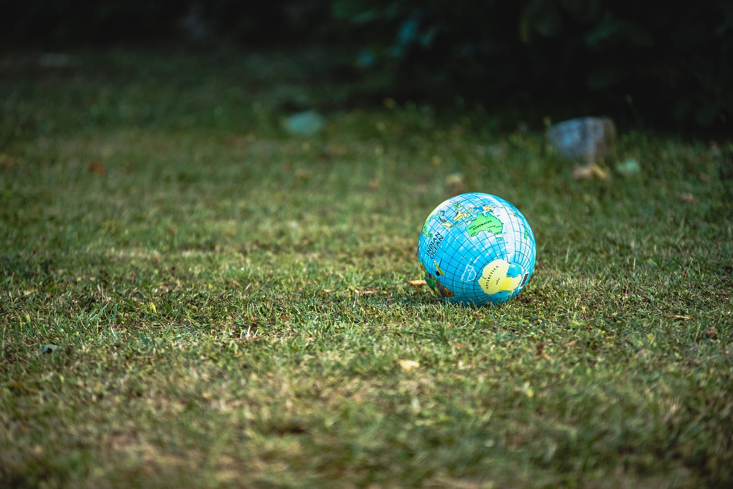 Inflated Earth as a soccer ball on a grassy field.