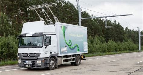 A small lorry connected to an overhead wire on a motorway