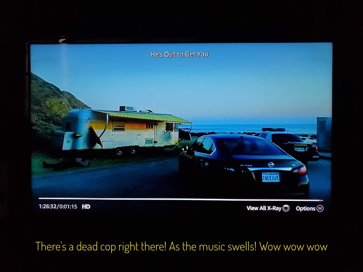 Duke's trailer, with a cop car and a dead sheriff in front of it, captioned "there's a dead cop right there! as the music swells! Wow wow wow"