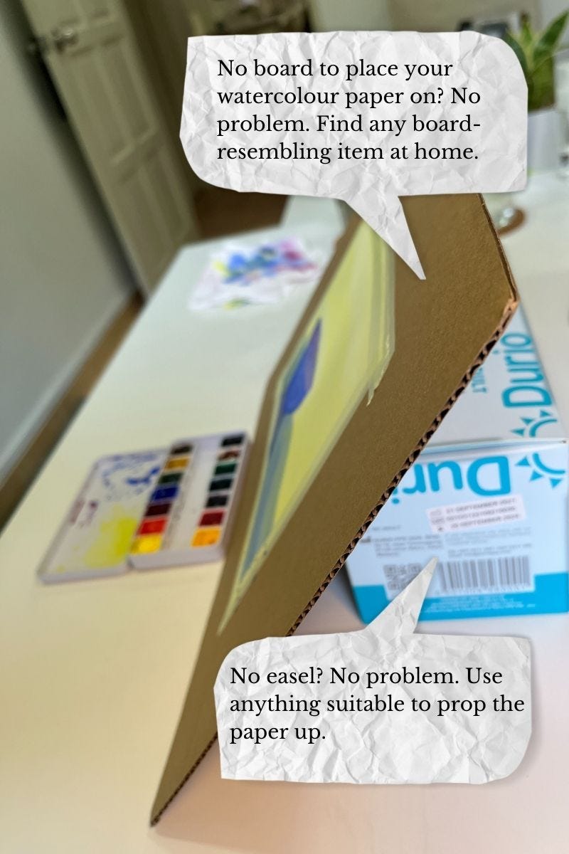 Image: a photo of my painting set-up. I used a packaging box (cut into a piece of board) to paste my watercolour paper on it (using washi tape). Then, I propped it up with a box (a box used to keep new face masks! Haha) The wording on the photo says:   No board to place your watercolour paper on? No problem. Find any board-resembling item at home.   No easel? No problem. Use anything suitable to prop the paper up. 