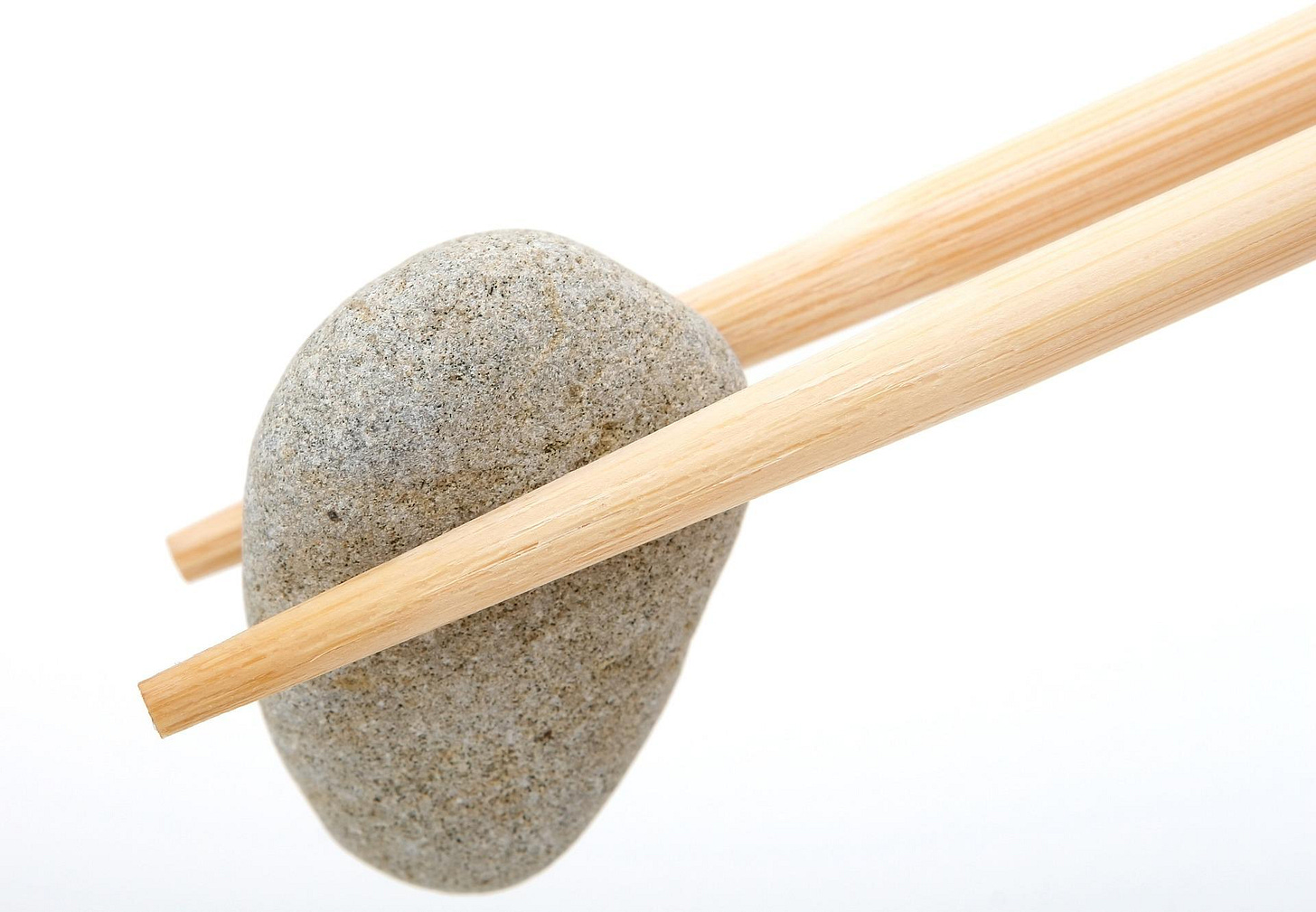 inedible rock in a pair of chopsticks