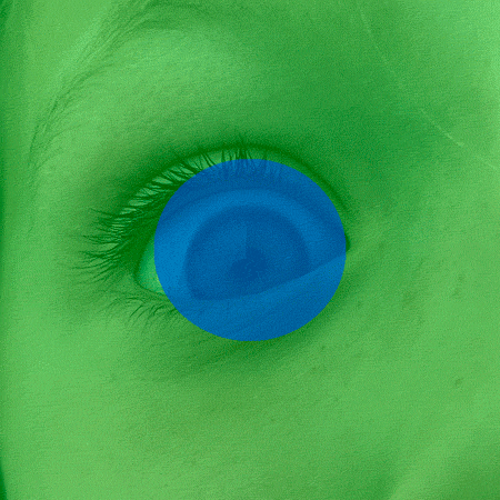 An animated-loop of a close-up photo of a right eye open in surprise and then crinkling into a smile. The eye is blue with light skin, though the whole frame is superimposed with a green transparency. Over the iris in the center of the frame is a blue transparent circle that doesn’t move throughout the animation.