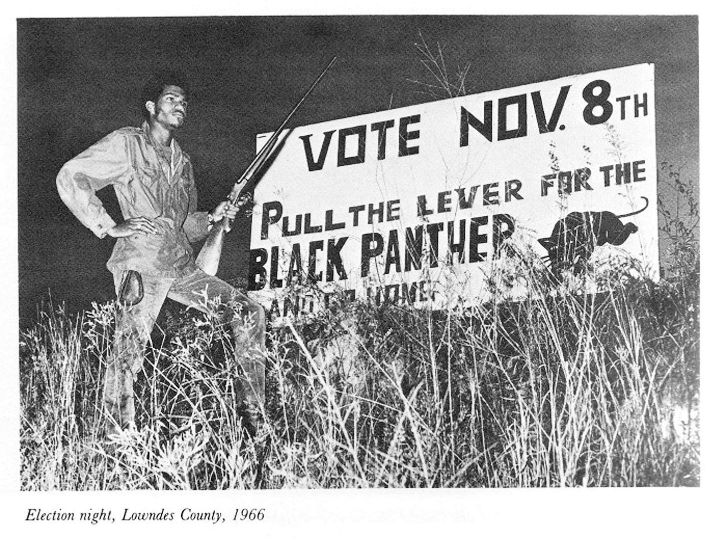 Film still from LOWNDES COUNTY AND THE ROAD TO BLACK POWER featuring a photo from 1966 with a Black man holding a rifle in front of a "Vote Black Panther" sign.
